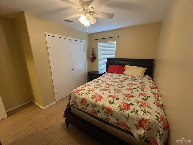 a bedroom with a bed and a flat tv screen on dresser