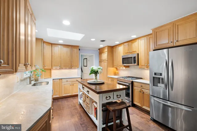 a kitchen with kitchen island granite countertop a stove refrigerator and microwave