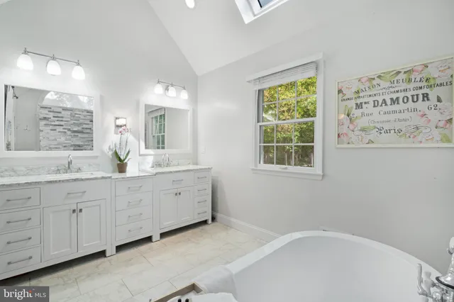 a spacious bathroom with sinks mirror and a bathtub
