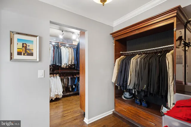 a view of walk in closet with clothes and shoes