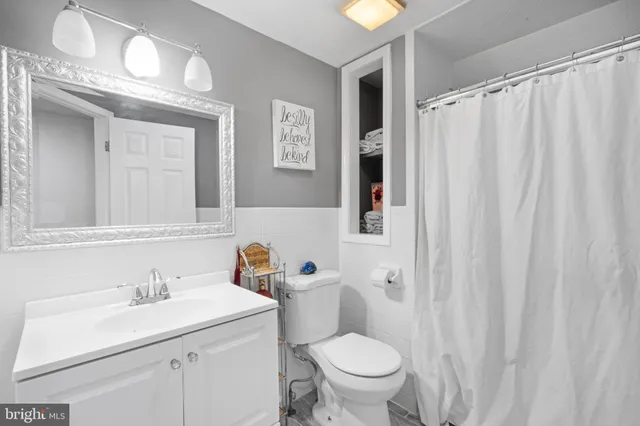 a bathroom with a sink a toilet and shower curtain