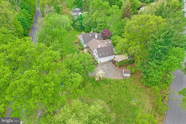 an aerial view of residential house with outdoor space and trees all around