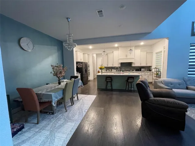 a living room with stainless steel appliances kitchen island granite countertop furniture a rug a fireplace and a kitchen view