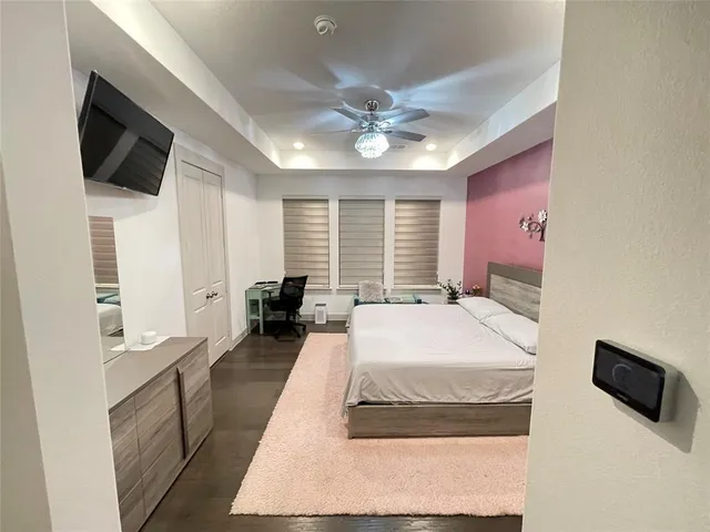 a spacious bedroom with a bed and a flat screen tv