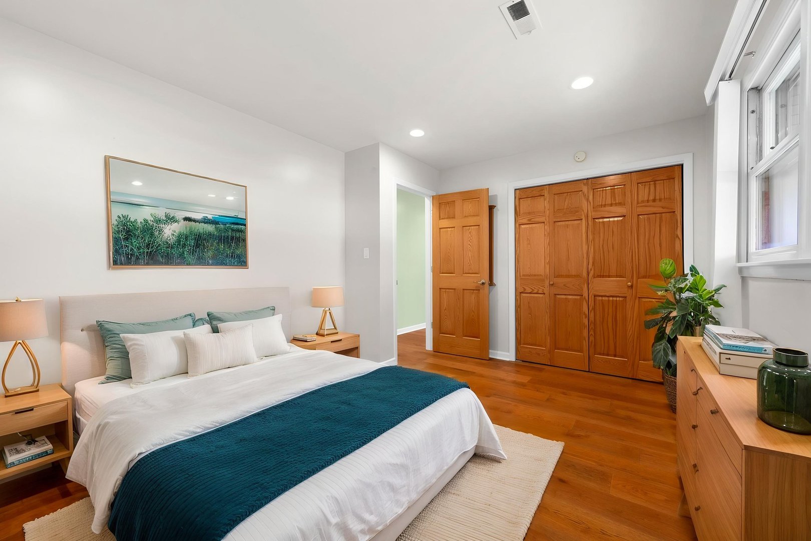 4433 Madison Avenue Brookfield, IL 60513 - Photo 10 of 16 a spacious bedroom with a large bed a potted plant and wooden floor