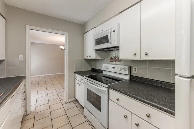 a kitchen with stainless steel appliances granite countertop a stove a microwave and a sink