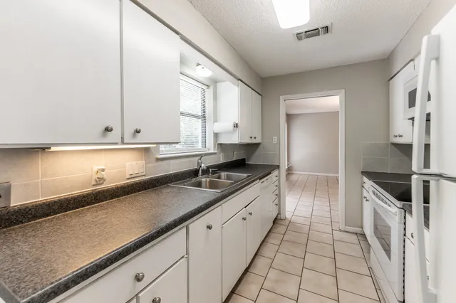 a kitchen with granite countertop a sink and cabinets