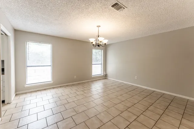 an empty room with windows and chandelier