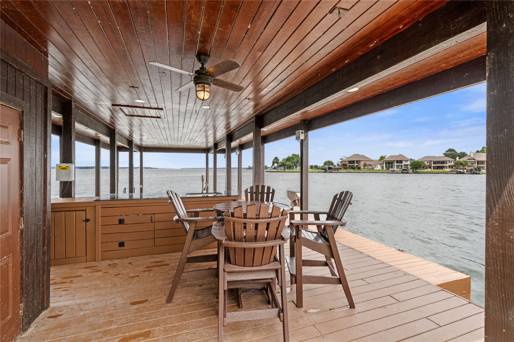 12349 Longmire Trace Conroe, TX 77304 - Photo 42 of 48 Covered fishing boat dock with wood-plank ceiling, ceiling fan, and built-in fish cleaning station.