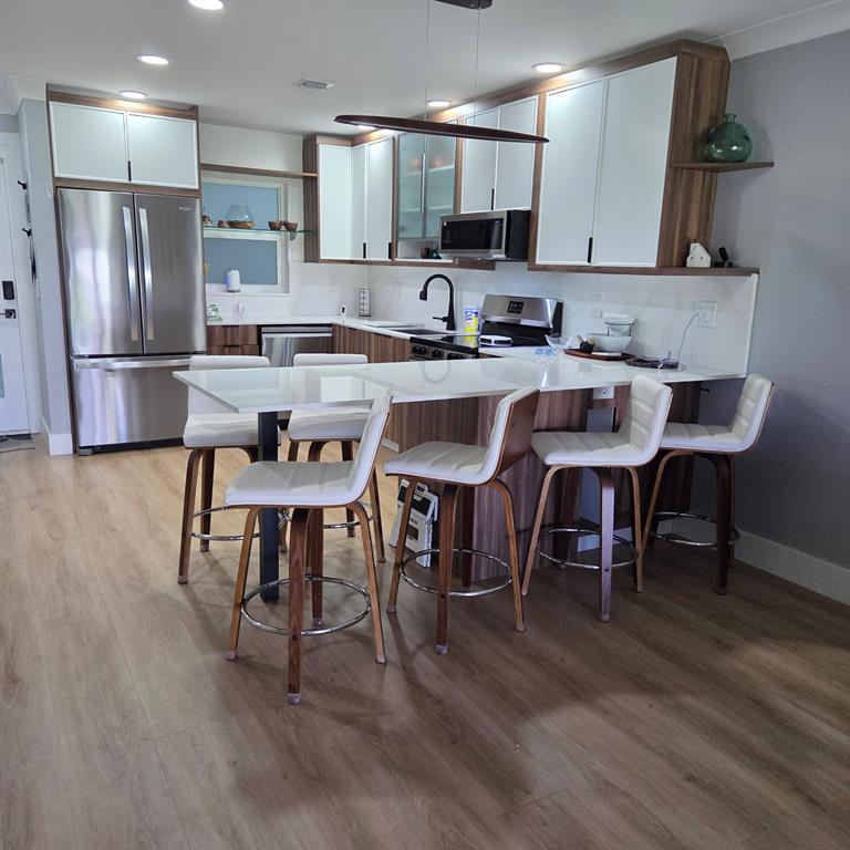 300 Southwest Golfview Terrace, Unit 135 Boynton Beach, FL 33426 - Photo 20 of 25 a kitchen with stainless steel appliances granite countertop a dining table chairs refrigerator and sink