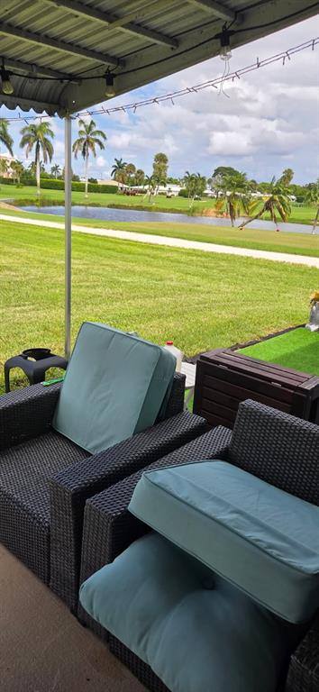 300 Southwest Golfview Terrace, Unit 135 Boynton Beach, FL 33426 - Photo 4 of 25 a view of a swimming pool with a table and chairs under an umbrella