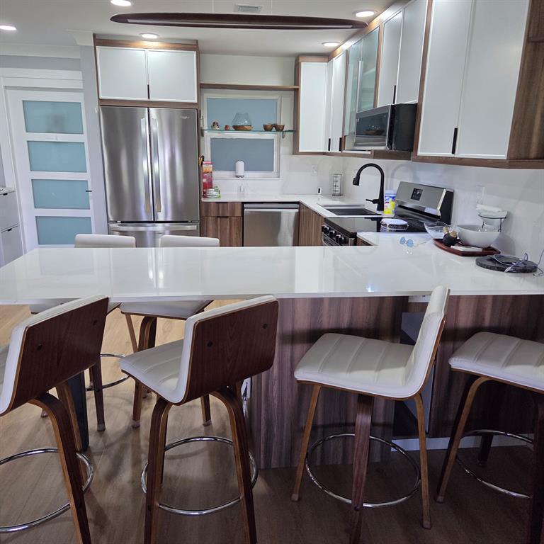 300 Southwest Golfview Terrace, Unit 135 Boynton Beach, FL 33426 - Photo 7 of 25 a kitchen with a dining table chairs and refrigerator