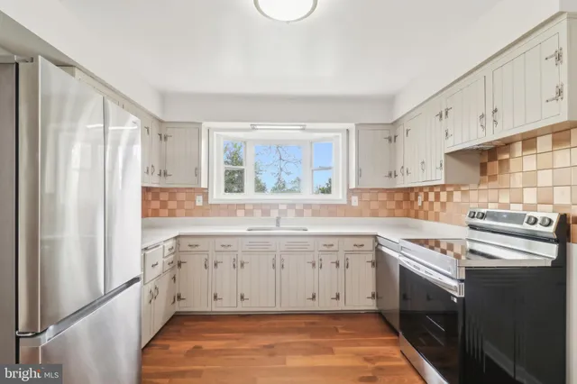 a kitchen with wooden floor and a stove top oven