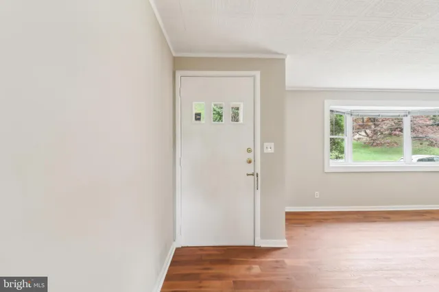 a view of empty room with wooden floor and fireplace