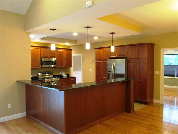 313 South Main Street Andover, MA 01810 - Photo 9 of 26 a kitchen with stainless steel appliances granite countertop a stove a refrigerator and a wooden cabinets