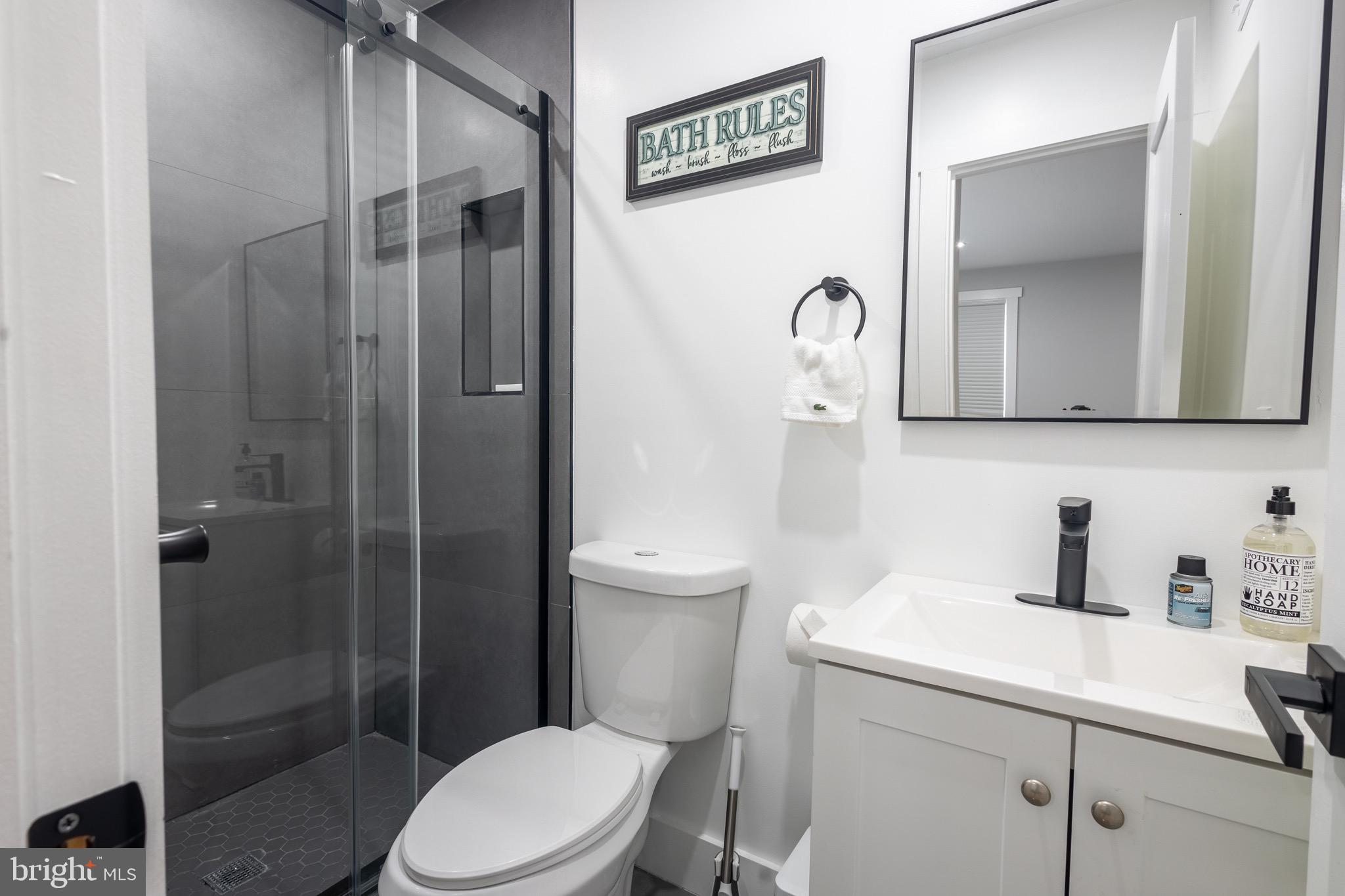 37 4th Street Laurel, MD 20707 - Photo 13 of 26 a bathroom with a toilet sink vanity and shower