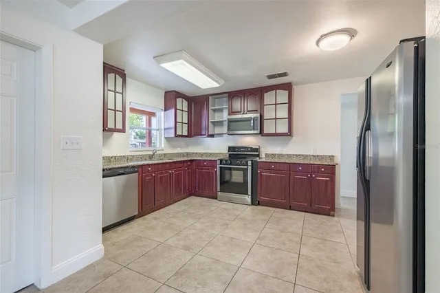 a kitchen with stainless steel appliances granite countertop a refrigerator and a stove