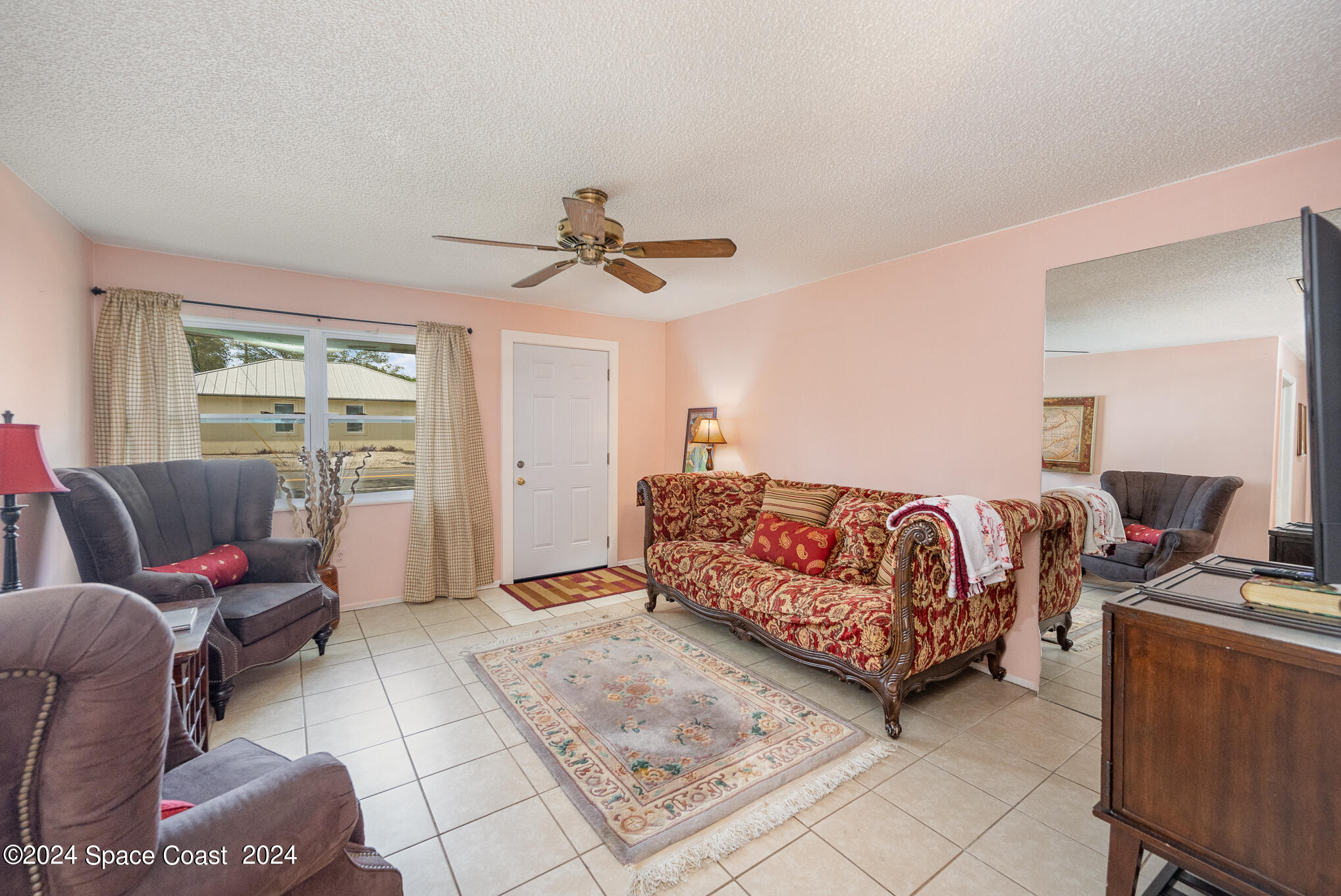 889-881 Sarno Road Melbourne, FL 32935 - Photo 13 of 25 a spacious bedroom with a bed a couch and a chandelier