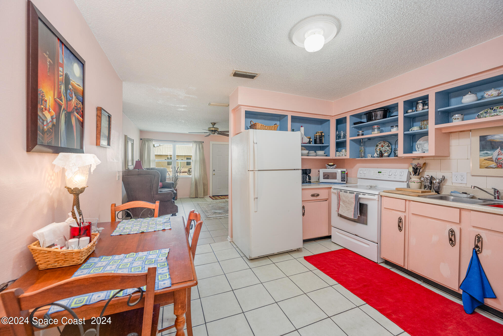 889-881 Sarno Road Melbourne, FL 32935 - Photo 14 of 25 a white kitchen with a refrigerator a stove a sink and cabinets