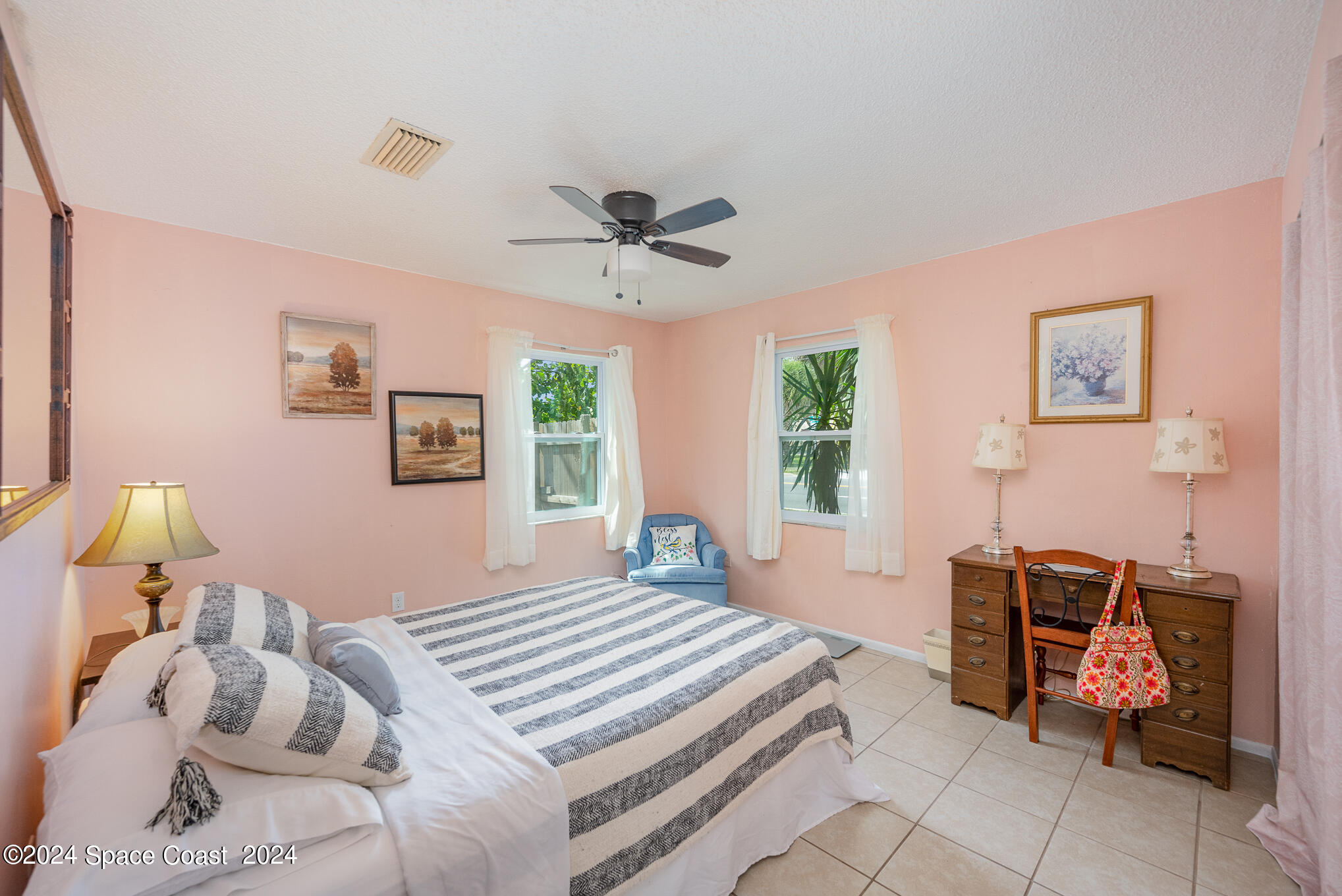 889-881 Sarno Road Melbourne, FL 32935 - Photo 16 of 25 a bedroom with a bed and a chandelier