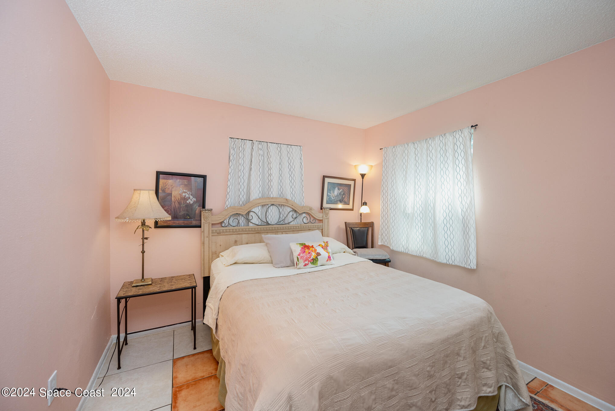 889-881 Sarno Road Melbourne, FL 32935 - Photo 17 of 25 a bedroom with a bed and a lamp