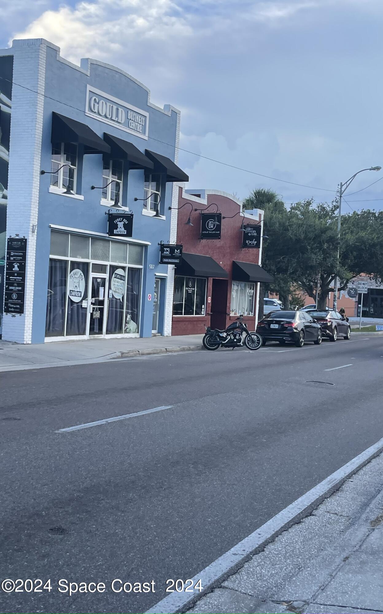 889-881 Sarno Road Melbourne, FL 32935 - Photo 25 of 25 a front view of a building with lot of cars parked on road