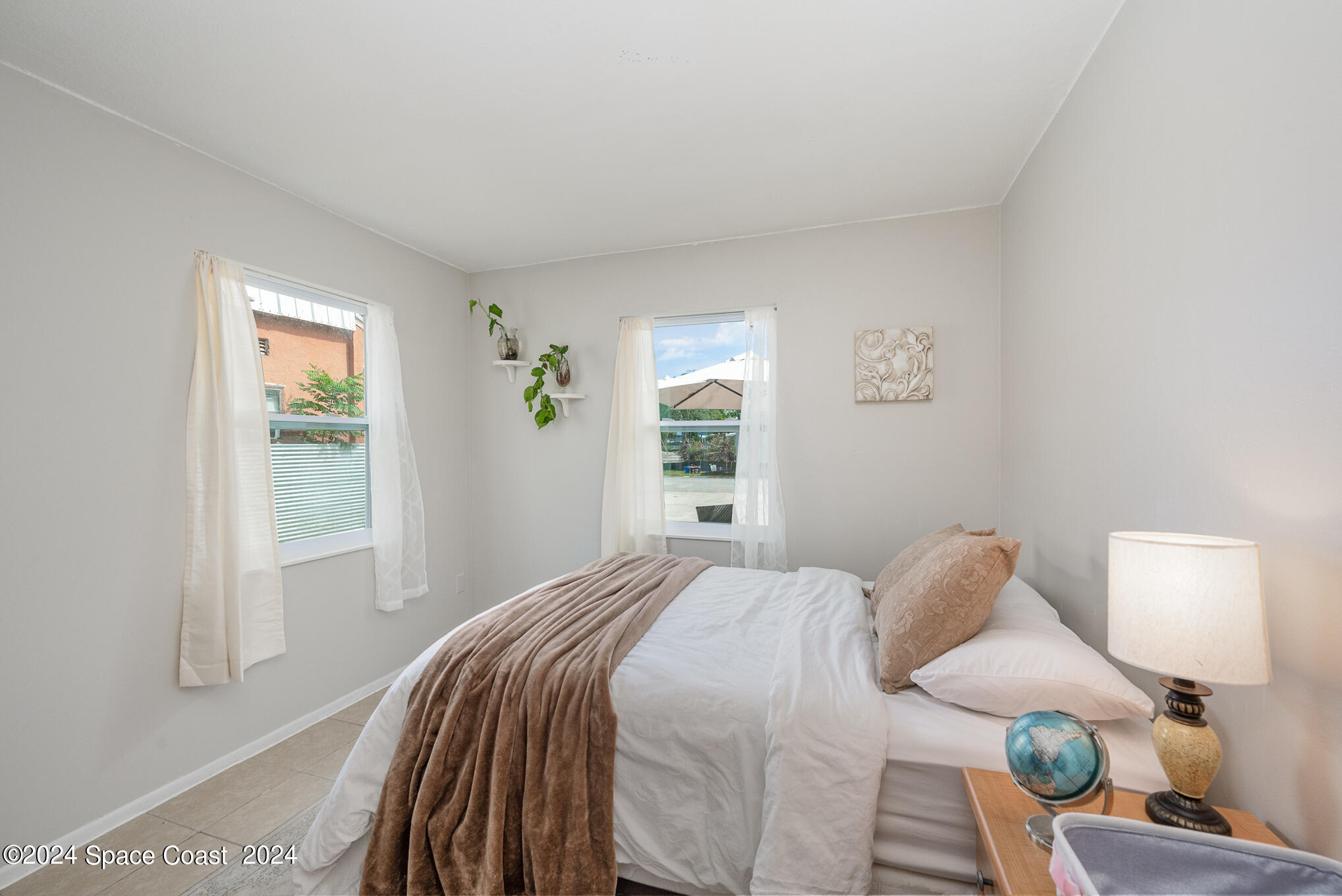 889-881 Sarno Road Melbourne, FL 32935 - Photo 8 of 25 a bedroom with a bed and a window