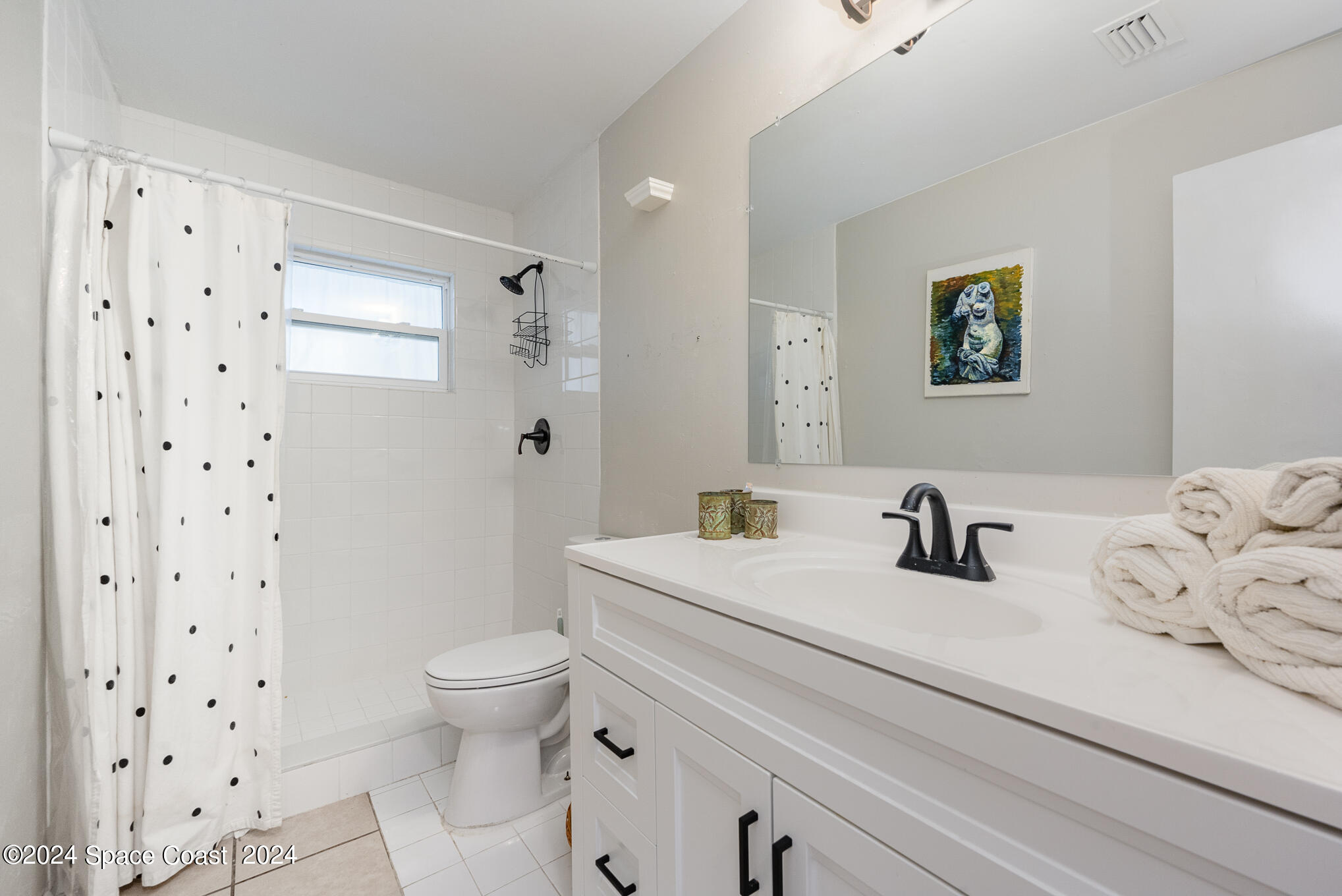 889-881 Sarno Road Melbourne, FL 32935 - Photo 9 of 25 a bathroom with a sink a toilet and a large mirror