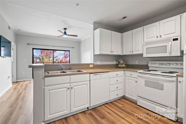 a kitchen with granite countertop white cabinets and white appliances