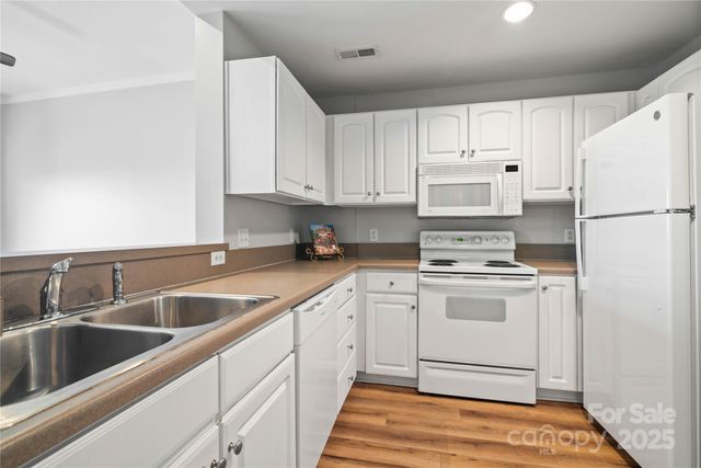 a kitchen with white cabinets sink and white appliances