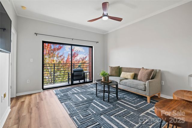 a living room with furniture large window and rug