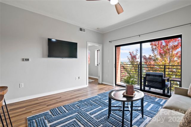 a living room with furniture a flat screen tv and a large window
