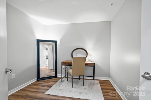 a view of a workspace with furniture and wooden floor