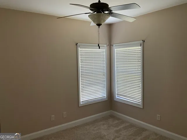 a view of a room with a ceiling fan and a window