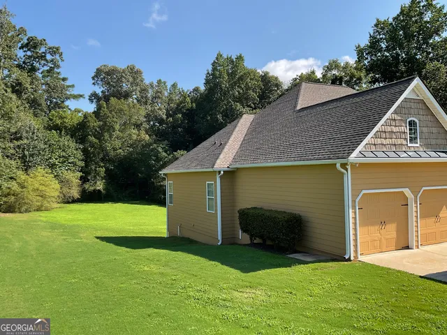 a front view of a house with a garden and yard
