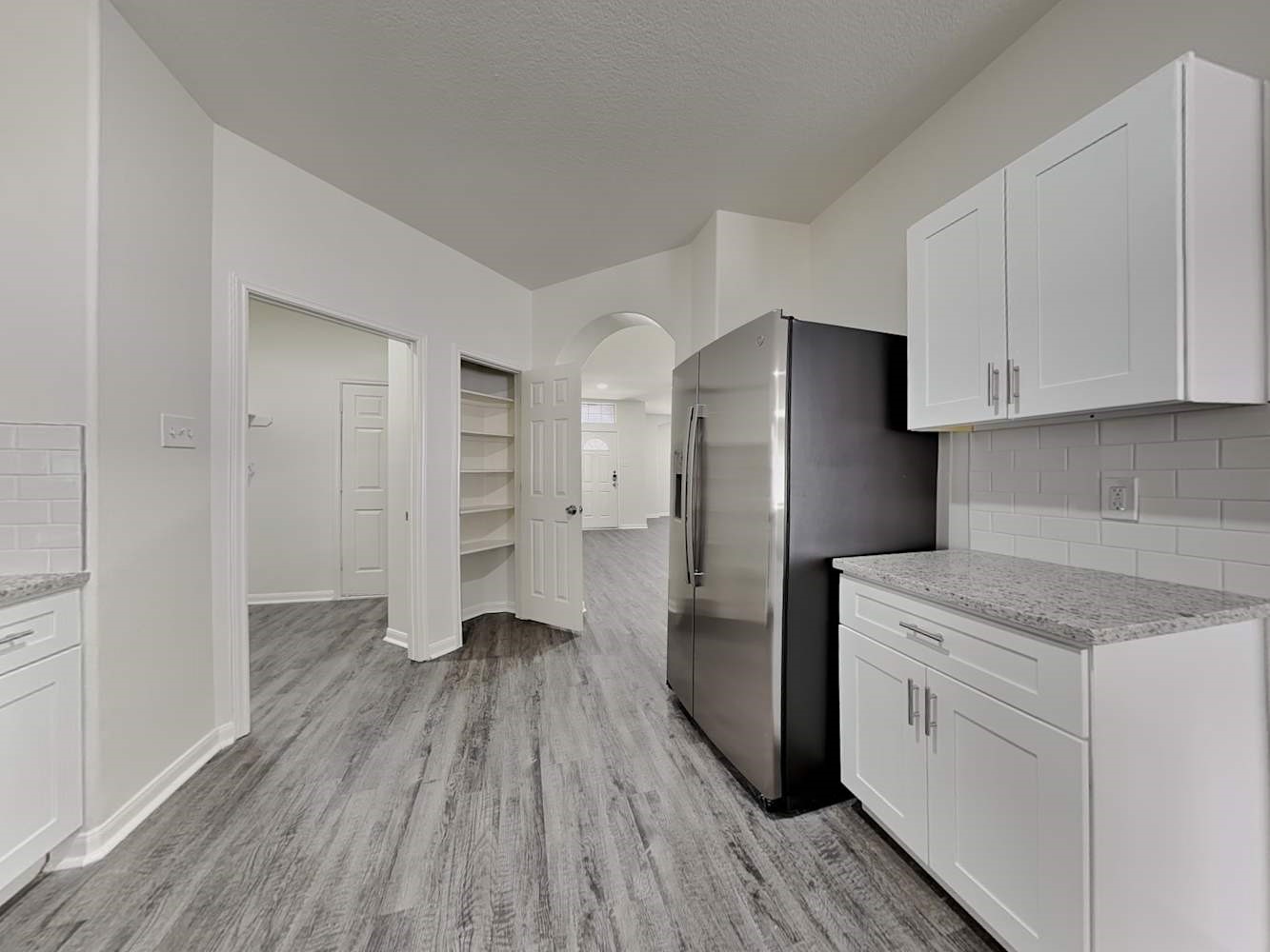 15407 Riford Drive Cypress, TX 77429 - Photo 5 of 13 a kitchen with a hard wood floor white cabinets and stainless steel appliances