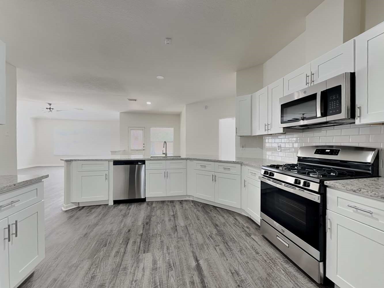 15407 Riford Drive Cypress, TX 77429 - Photo 6 of 13 a kitchen with stainless steel appliances granite countertop a stove a sink and a microwave