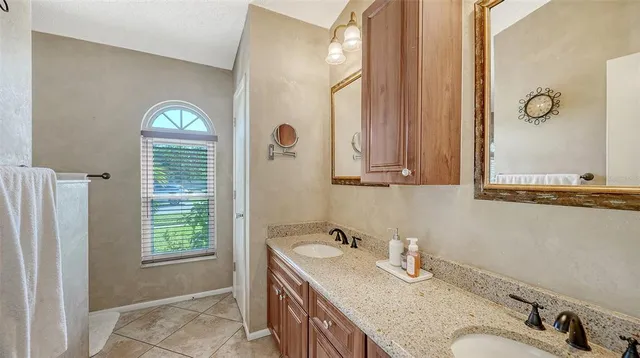 a bedroom with a bed a mirror and a potted plant