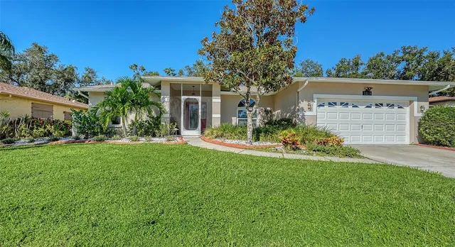 a view of a house with a big yard and potted plants
