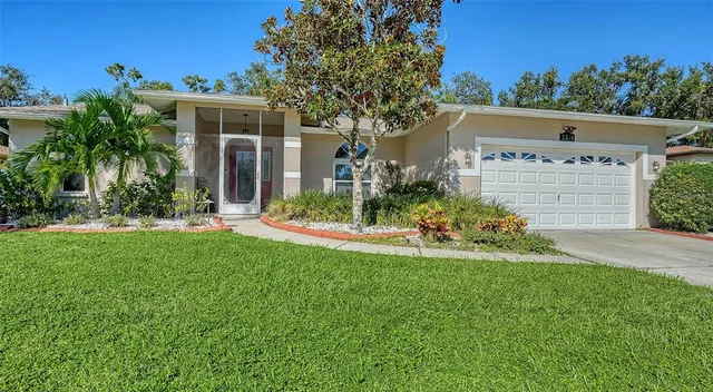 a view of a house with a yard and potted plants