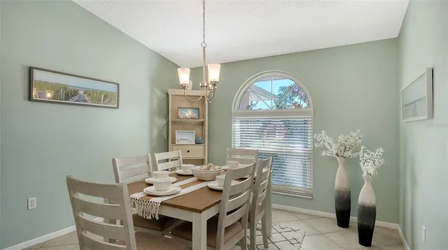 a view of a dining room with furniture a chandelier and window