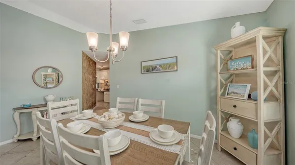 a view of a dining room with furniture a chandelier and wooden floor