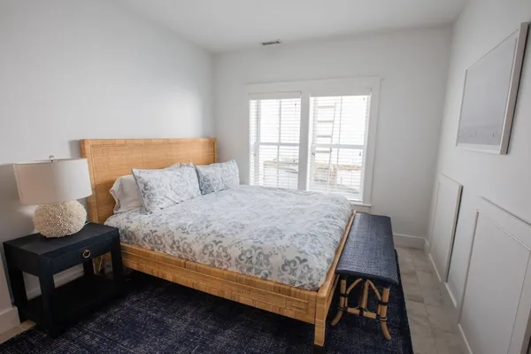 a bedroom with a bed a window and wooden floor