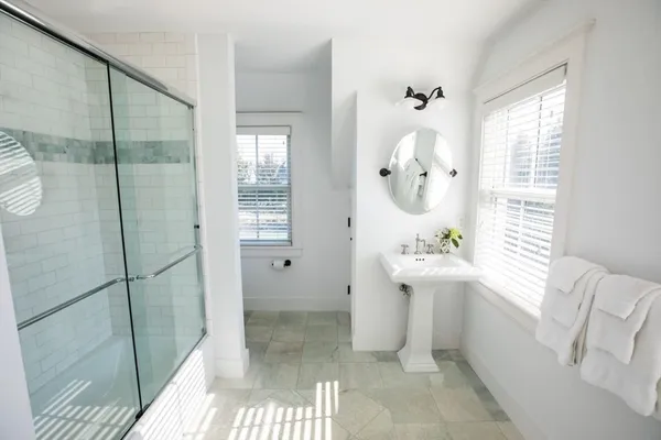 a bathroom with a sink a toilet and shower