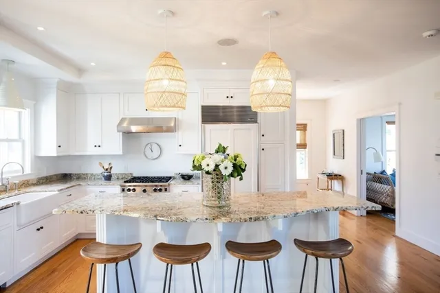 a kitchen with stainless steel appliances granite countertop a table and chairs in it