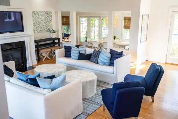 a living room with fireplace furniture and a large window
