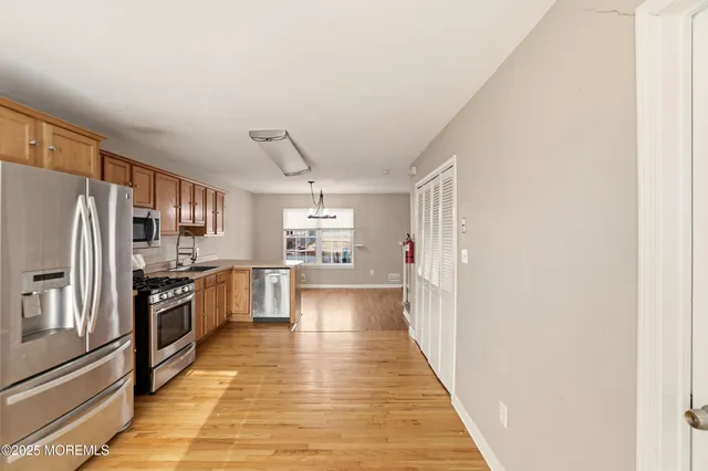 a kitchen with granite countertop a refrigerator and a stove top oven