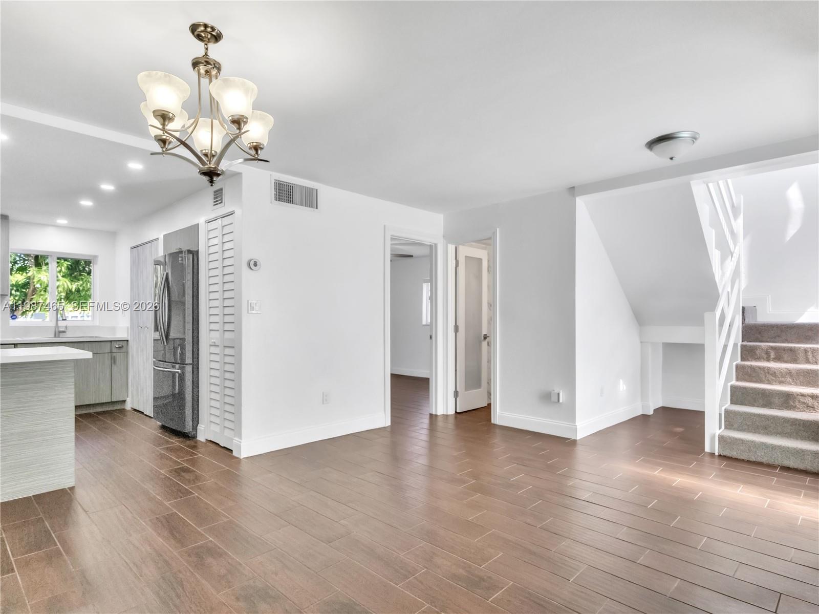 6505 Southwest 113th Place Miami, FL 33173 - Photo 2 of 25 a view of a livingroom with wooden floor and a chandelier