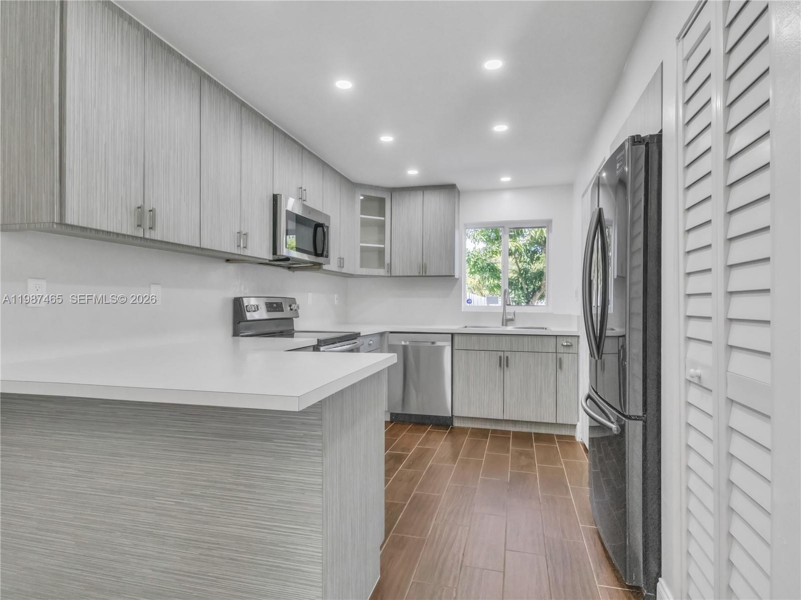 6505 Southwest 113th Place Miami, FL 33173 - Photo 3 of 25 a kitchen with a refrigerator sink and cabinets