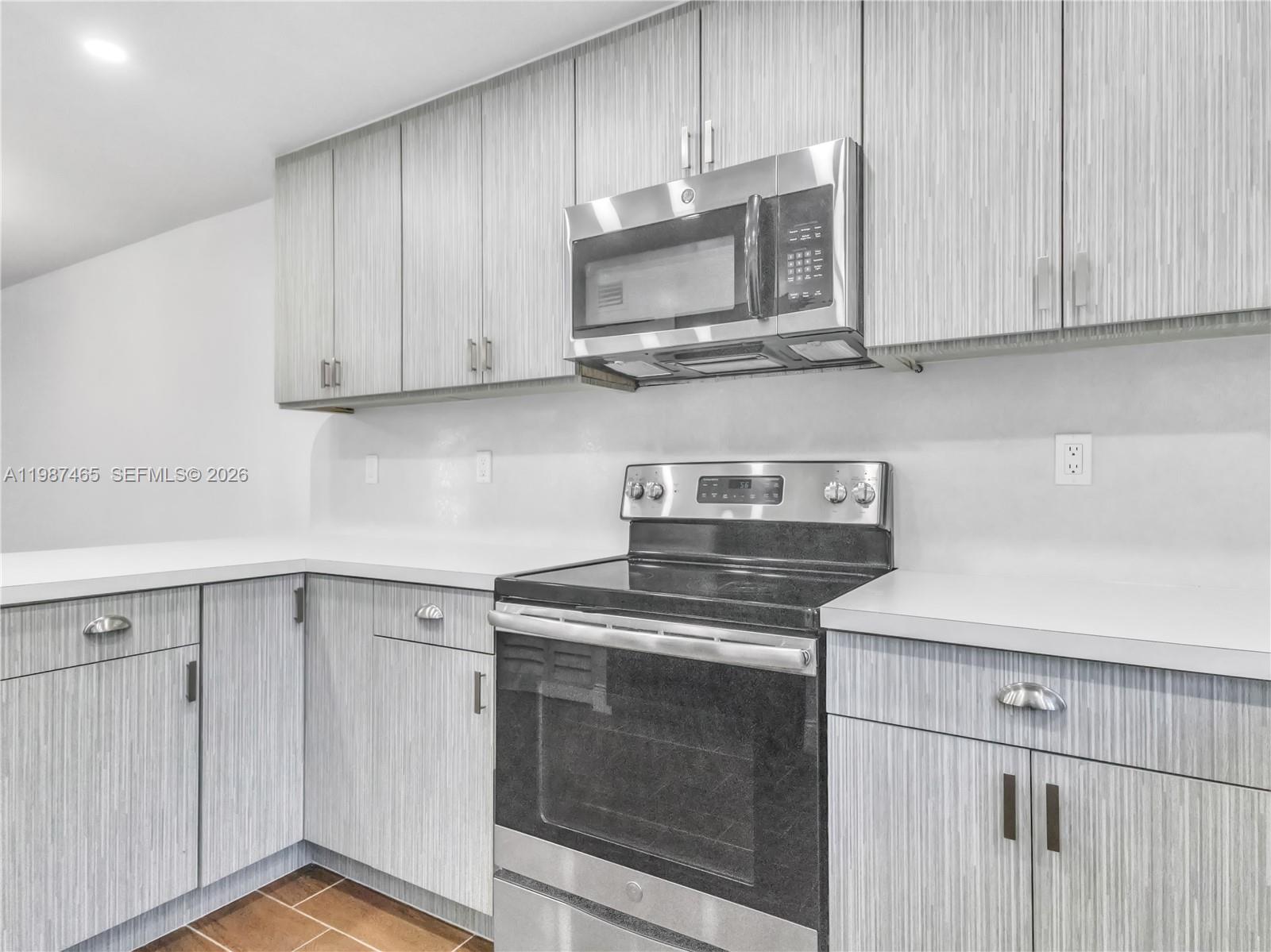 6505 Southwest 113th Place Miami, FL 33173 - Photo 5 of 25 a kitchen with stainless steel appliances granite countertop white cabinets a sink and dishwasher